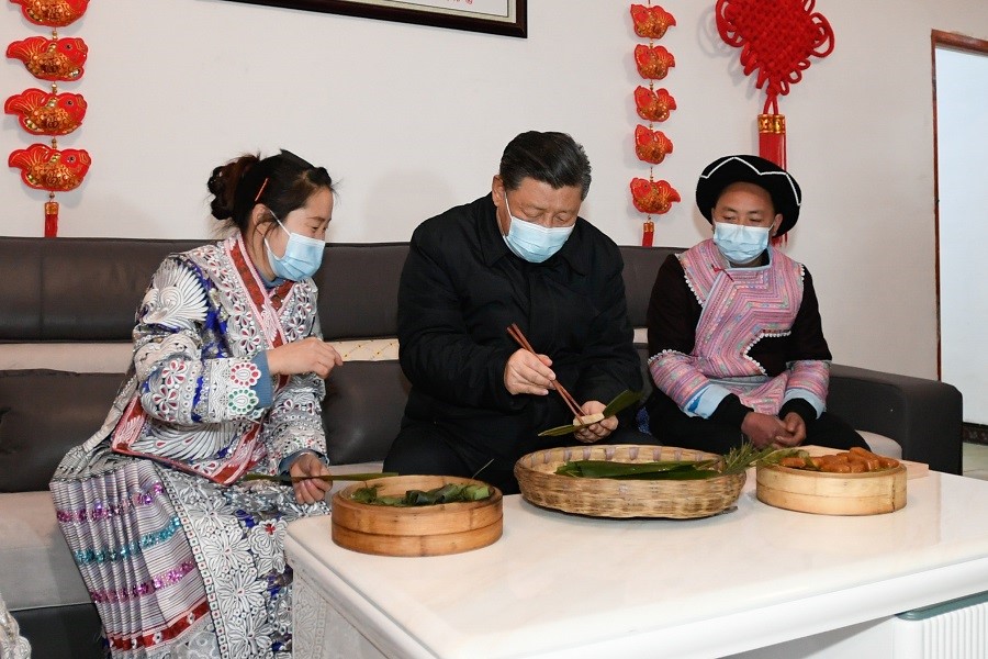 2021年2月3日下午，習(xí)近平在貴州畢節(jié)市黔西縣新仁苗族鄉(xiāng)化屋村苗族村民趙玉學(xué)家，同一家人邊聊家常邊制作當(dāng)?shù)貍鹘y(tǒng)節(jié)日食品黃粑。新華社記者 李學(xué)仁 攝